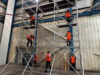 A group of people in orange vests standing on scaffolding

AI-generated content may be incorrect.